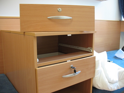 Kép egy fiókos szekrényről, két (külön) kulccsal zárható fiókkal. Ha a felső fiókot kiszedjük a helyéről, akkor az alsóba minden gond nélkül be lehet nyúlni, mert nincs elválasztó bútorlap a kettő között.